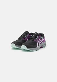 Zapatillas negras para correr con detalles en morado, que cuentan con una parte superior de malla, suelas gruesas con una suela exterior verde menta y cordones contrastantes.