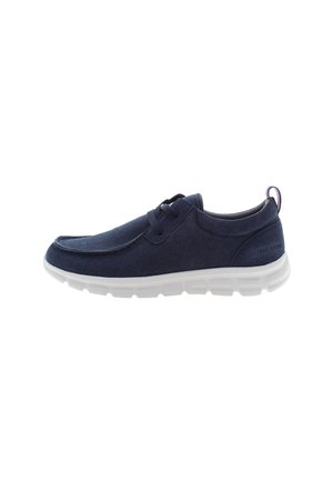 Scarpa slip-on in tela blu navy con punta arrotondata, suola flessibile bianca e dettagli di cucitura discreti. Caratterizzata da design con lacci e un accento posteriore.