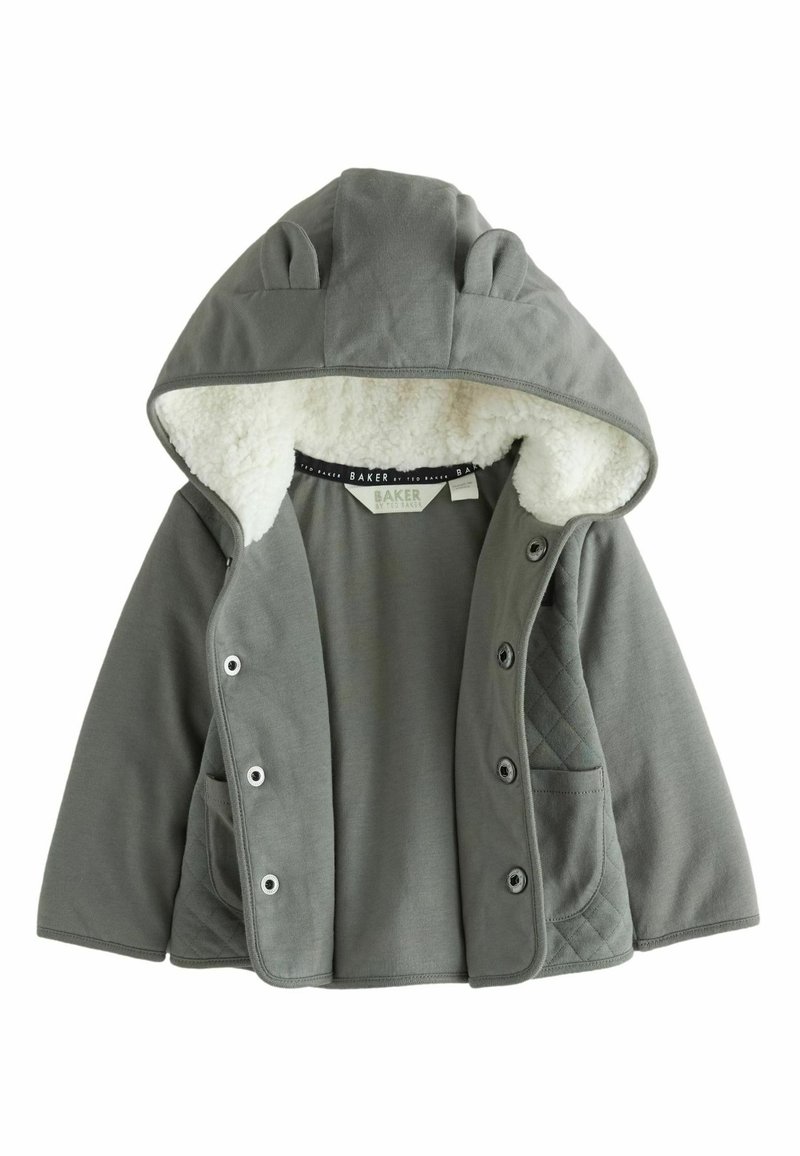 Grå hættejakke med en blød, hvid fleece-foring, der har trykknapper, to sidelommer og quiltede detaljer på ærmerne.