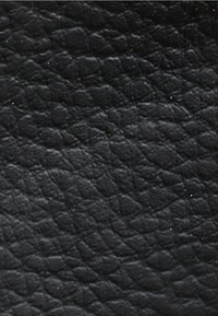 Schwarze Ledertextur mit einer genarbten Oberfläche und leichtem Glanz, die kleine, unregelmäßige Muster aufweist.