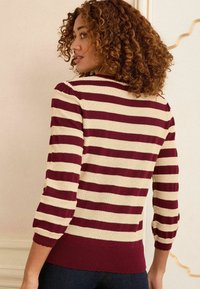 Pulover raiat în tonuri de burgund și crem, cu mâneci trei sferturi, margine ribbată și un model texturat de tricot.