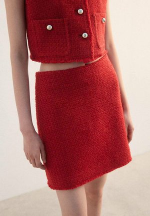 Red textured knit crop top with two front pockets and silver buttons, paired with a matching red pencil skirt. Both pieces have a fuzzy finish.