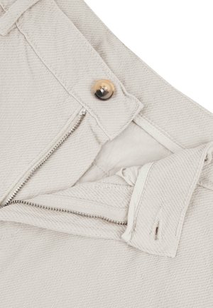 Beige Baumwollhosen mit einem Reißverschluss und metallischem Beschlag sowie einem Knopfverschluss. Strukturierter Stoff mit diagonalen Rippen.