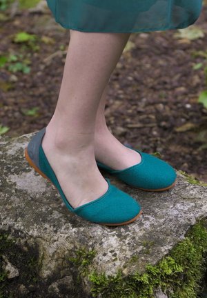 Teal platte schoenen van stof met een afgeronde teen ontwerp. Grijze accenten op de hak en een flexibele bruine zool.