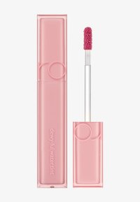 Tube rose de teinte hydratante avec une finition douce au toucher, accompagné d'un applicateur en pied de cerf avec une pointe texturée pour une application uniforme.