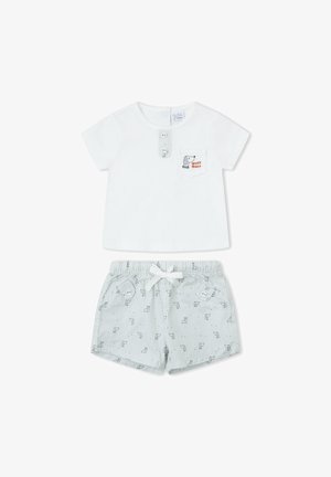 Camiseta blanca de bebé de manga corta con un perro y "guau guau" en el bolsillo, combinada con pantalones cortos a rayas claras con pequeños estampados de animales y cintura con cordón.