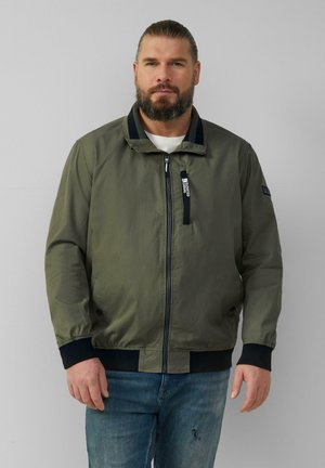 Olivgrüne Bomberjacke mit Stehkragen, Reißverschluss und schwarzen Akzenten an den Bündchen und am Saum. Hergestellt aus glattem, leichtem Stoff.