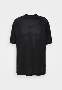 Svart nät kortärmad T-shirt med rund hals och en reflektiv logotyp på framsidan. Har ett ventilerande, texterat tyg.