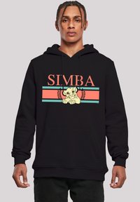 Felpa nera con cappuccio caratterizzata da una grafica con il testo "SIMBA", un'immagine di un cucciolo e accenti decorativi nei colori corallo e teal. Materiale in cotone.
