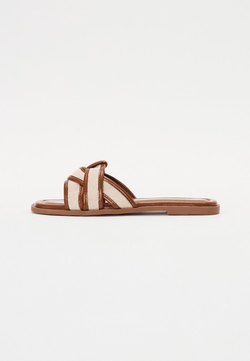 Brune flade sandaler med tekstilremme med et vævet mønster og en glat gummisål. Minimalistisk design med åben tå.