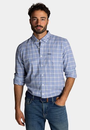 Lichtblauw geruit overhemd met button-down kraag, kort opgerolde mouwen en geborduurd logo. Draagt het met donkere jeans en een geweven riem.