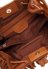Indvendig i den brune ruskinds håndtaske er der en enkelt lynlåslomme, glat foring og en magnetisk trykknaplukning. Kompakt design med rene sømme.