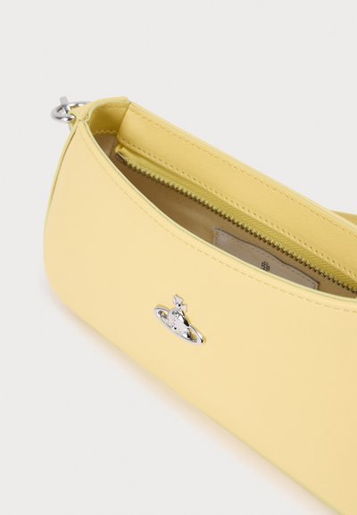 Κίτρινη δερμάτινη τσάντα με λεία υφή, κλείσιμο με φερμουάρ και ασημένια λεπτομέρεια λογότυπου στο εμπρόσθιο μέρος. Συμπαγές σχήμα κατάλληλο για τα απαραίτητα.