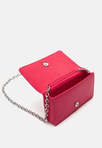Červené kožené psaníčko se stříbrným řetízkovým popruhem, uzavíratelné na patentku, s vnitřními přihrádkami na karty, hladkou texturou a jednoduchým designem.