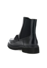Botine negre din piele cu panouri laterale elastice, vârf rotunjit și talpă din cauciuc texturat. Include un detaliu cusut de-a lungul marginii tălpii.