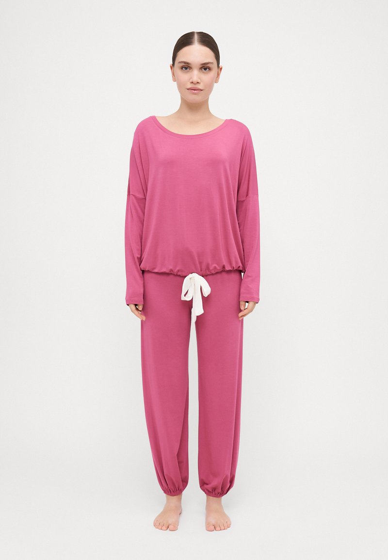 Ροζ σετ νυχτικών με μακριά μανίκια και ελαστική μέση. Το παντελόνι διαθέτει λευκή κορδόνι. Μαλακή, λεία υφή.
