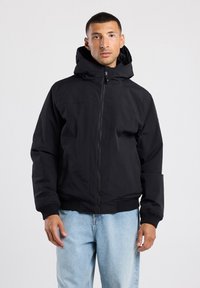 Schwarze kapuzenjacke mit Reißverschluss, gerippten Bündchen und Saum sowie Seitentaschen. Hergestellt aus glattem, wasserabweisendem Material. Lässiger Schnitt.