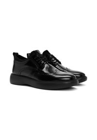 Zwarte leren oxford schoenen met een gladde afwerking, voorzien van gedetailleerde brogue accenten, vetersluiting en een dikke rubberen zool.