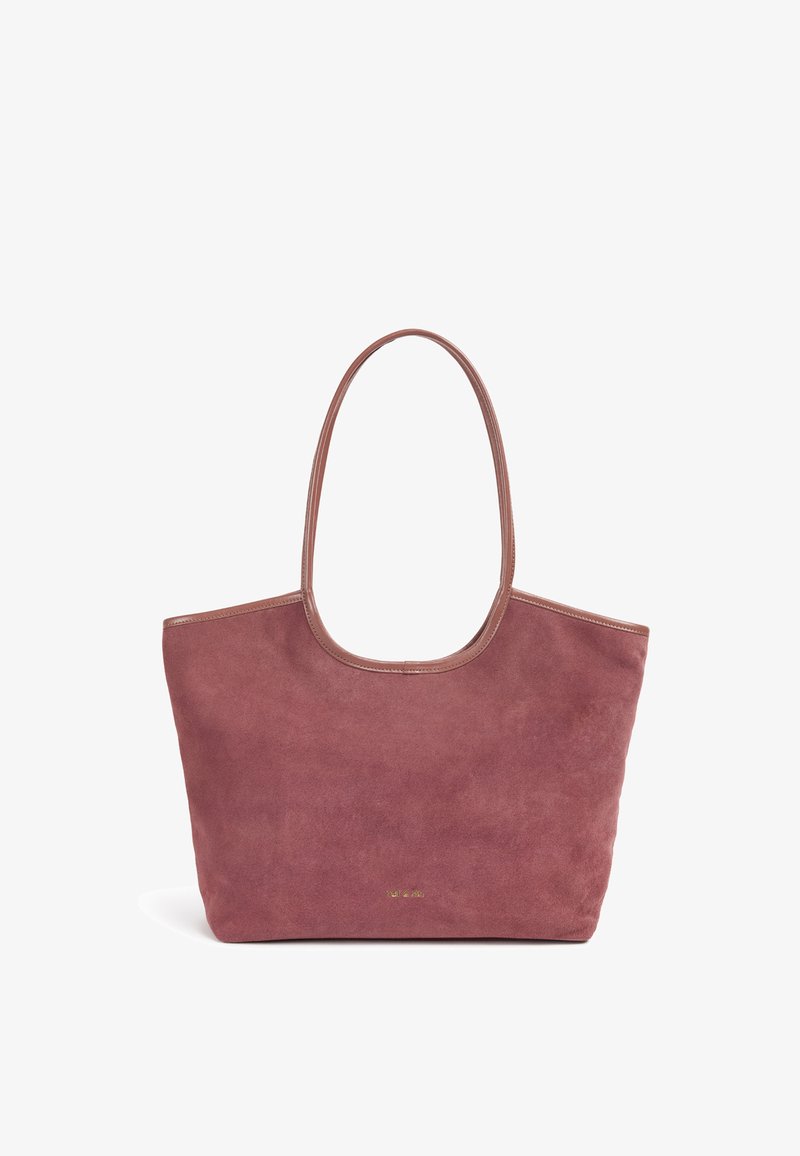 Sac fourre-tout en daim de couleur rose discrète avec une bordure en cuir lisse. Comprend une grande ouverture supérieure et deux bandoulières flexibles.