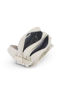 Sac bandoulière beige avec trois compartiments zippés, poches en mesh à l'intérieur, et bandoulière réglable avec boucle, présenté ouvert sur fond blanc.