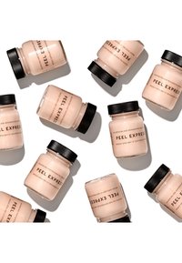 Twee stijlen van matglazen potten liggen op een witte achtergrond, met een lichtroze product genaamd "Peel Express" erin, met zwarte schroefdeksels.