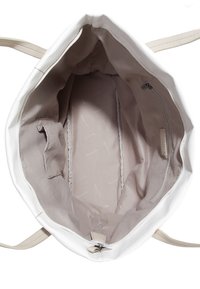 Wnętrze białej skórzanej torby tote z beżową podszewką, z kieszenią na zamek i boczną kieszenią na dokumenty. Gładka faktura, prosty design.