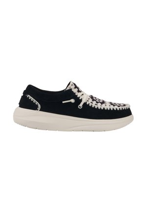 Black suede shoe with a white woven design on the toe and white laces. Features a cushioned white rubber sole and stitching detail.