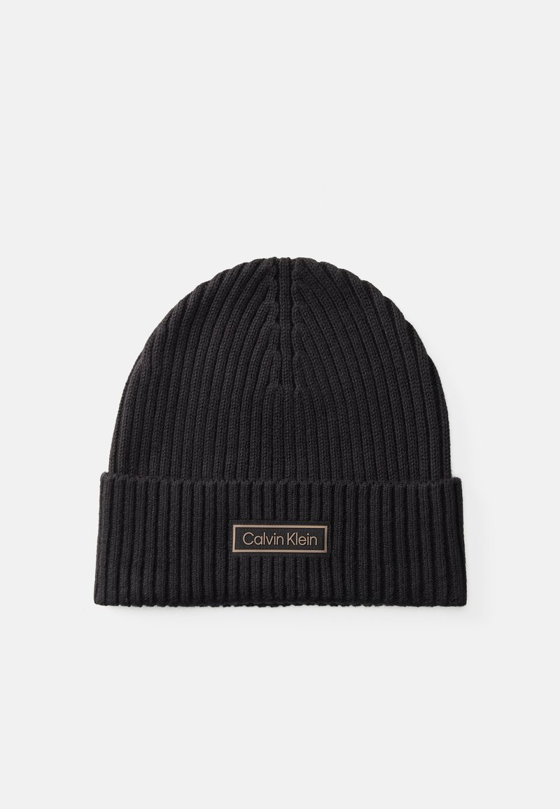 Czarna, prążkowana czapka beanie z podwiniętym mankietem oraz prostokątną naszywką z logo "Calvin Klein" w złotym kolorze.