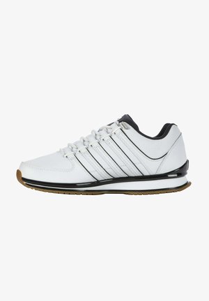 Witte sportieve schoenen met een gladde leren bovenkant, zwarte accenten, zes oogjes en een gumrubberen buitenzool. Voorzien van een gevoerde zool en een slank design.