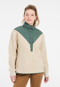 Fleece pullover met een beige lichaam en groene kraag, voorzien van knoopsluiting en voorzakken. Gestructureerde stof met contrasterende kleuren.