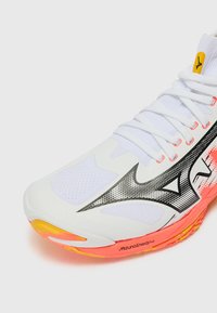 Scarpa da corsa bianca con overlay in mesh e sintetico, caratterizzata da un design a onde nere, dettagli arancioni sulla suola e un sistema di allacciatura prominente.