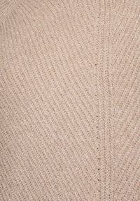 Beež kudum kangas diagonaalse soonikmustriga, millel on pehme tekstuur ja ühtlane silmuste korrapära, luues õrna visuaalse rütmi.