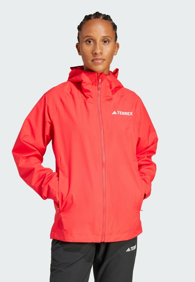 Red waterproof jacket with a hood, featuring a full-length zipper, side pockets, and a white "TERREX" logo on the chest.