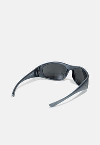 Occhiali da sole con una montatura nera elegante, lenti scure e una superficie liscia. Presentano stanghette curve e un piccolo logo decorativo.