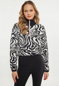 Reißverschluss-Pullover mit einem schwarz-weißen, wirbelnden Muster, ausgestattet mit einem hohen Kragen und gerippten Bündchen, hergestellt aus einem weichen, strukturierten Stoff.
