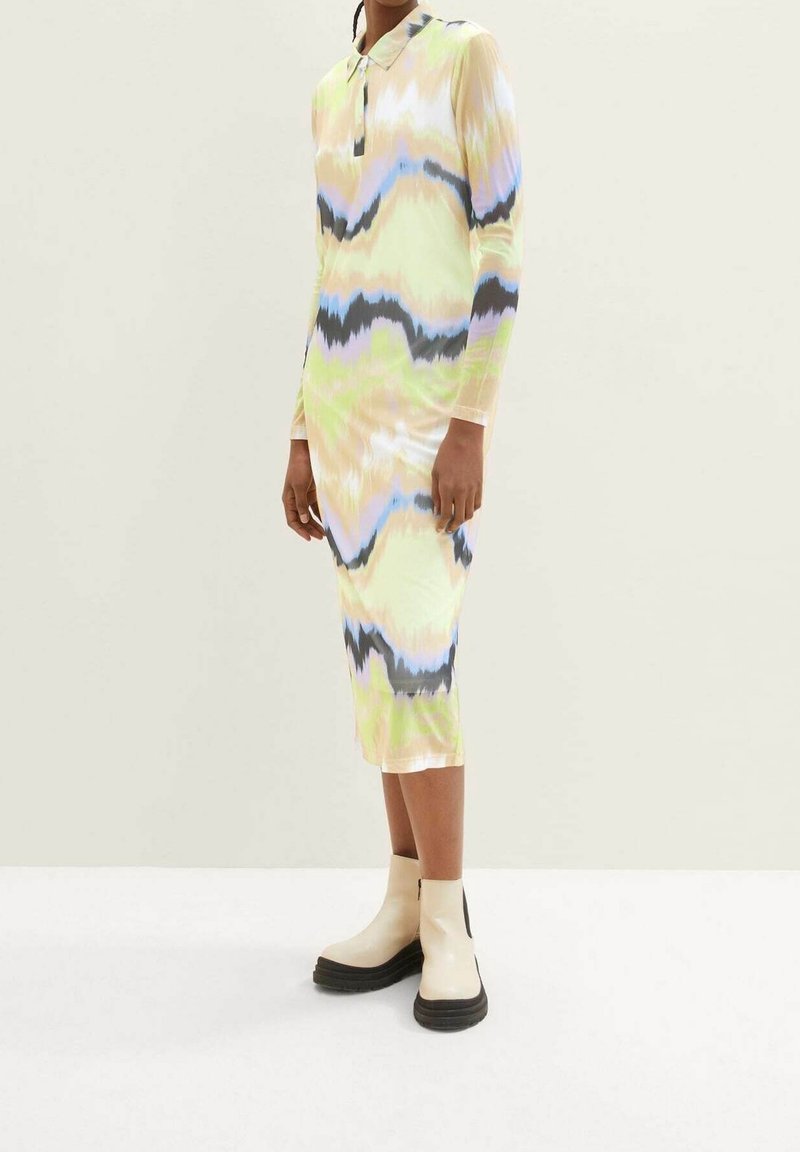 Robe à manches longues avec col, dans un motif ondulé multicolore comprenant des nuances de vert, bleu et noir. Elle présente une coupe ajustée et une longueur jusqu'aux genoux.