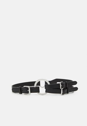 Ceinture en cuir noir avec boucles doubles argentées et un grand anneau rond argenté au centre, présentée sur fond blanc.