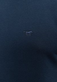 Pull-over en maille bleu marine avec un petit motif de cheval brodé en bleu légèrement plus clair. Texture douce et coupe près du corps.