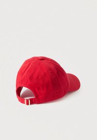Červená bavlnená baseballová čiapka so zaoblenou korunou, nastaviteľným remienkom vzadu a vetracími otvormi. Hladký povrch bez vzorov.