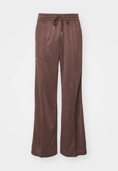 Bruine, brede sweatpants gemaakt van zachte stof, met een elastische tailleband met een trekkoord en zijzakken. Glad textuur.