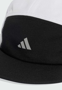 Cappello bianco e nero con una parte superiore testurizzata e un visiera nera uniforme. Presenta un logo Adidas argentato sulla parte anteriore, che mette in evidenza il suo marchio.