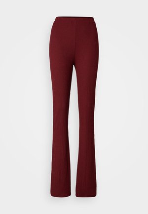 Pantaloni flare burgundy cu o textură canelată, având un tiv elastic și un design până la gleznă.