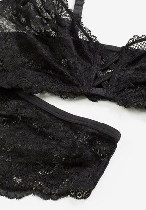 Bralette en dentelle noire avec bas assorti à motif floral, tissu texturé, bretelles ajustables et taille élastique.