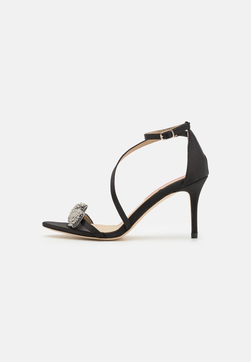 Black satin high-heeled sandal with an open toe, slender ankle strap, and decorative rhinestone accent on the front.