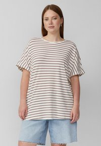 Gestreiftes kurzärmeliges T-Shirt in Beige mit burgunderroten Streifen; entspannte Passform und runder Ausschnitt. Kombiniert mit hellen Jeans-Shorts.