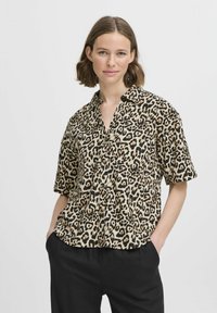 Košeľa na gombíky s krátkymi rukávmi, leopardí vzor v béžovej a čiernej farbe. Má golier a voľný strih, vyrobená z ľahkého materiálu.