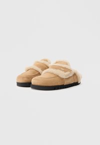 Pantofole in suede beige con fodera in pelliccia, design a scivolo, punta arrotondata, suola nera spessa e una fascia decorativa sulla parte superiore.