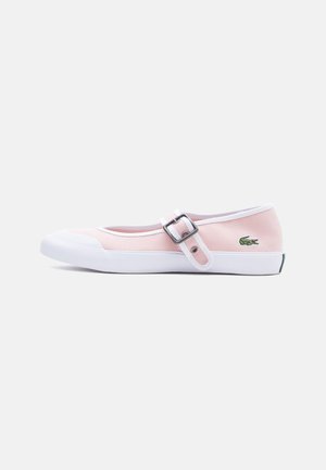 Light pink canvas Mary Jane sneaker with white rubber sole, white toe cap, adjustable buckle strap, and green crocodile logo on side.