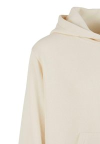 Hanorac crem deschis cu glugă, buzunar frontal și mâneci lungi, realizat dintr-un material moale de bumbac.