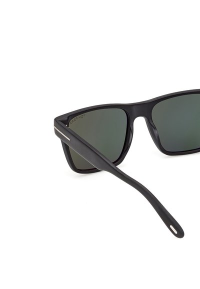 Lunettes de soleil rectangulaires noires avec des verres foncés et de fines touches argentées sur les branches, présentées sur fond blanc.